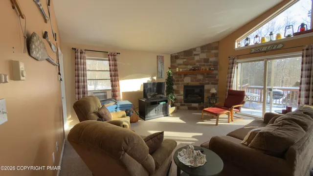 a living room with fireplace furniture and a large window
