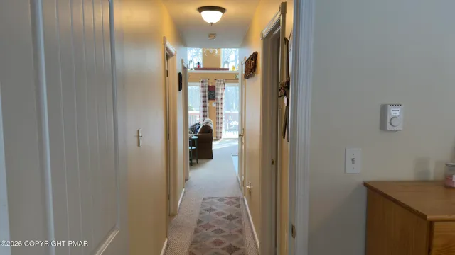 a view of a hallway with a livingroom and a bathroom