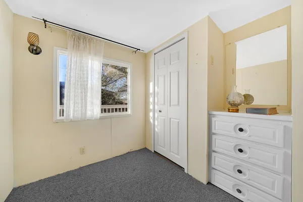 a bathroom with a granite countertop toilet sink and mirror