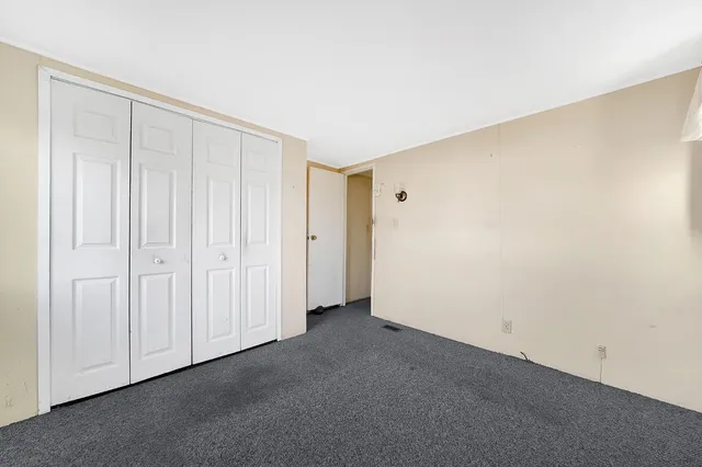 a view of a small barn with a small yard and large trees