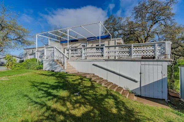 a view of a house with wooden deck and furniture
