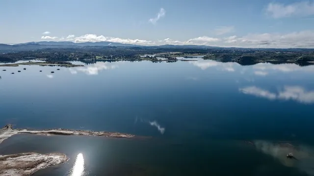 a kitchen with stainless steel appliances granite countertop a refrigerator a sink dishwasher and a stove with wooden floor