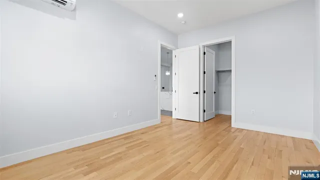 an empty room with wooden floor and mirror