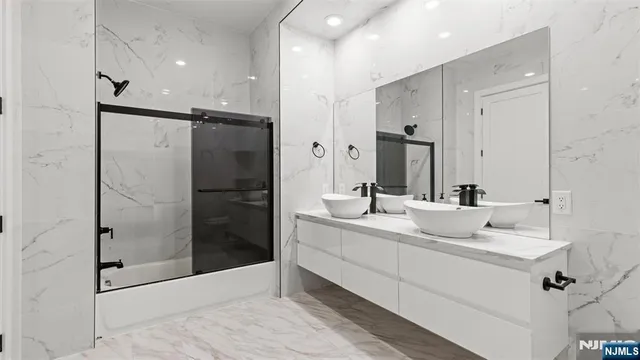 a bathroom with a double vanity sink mirror and shower