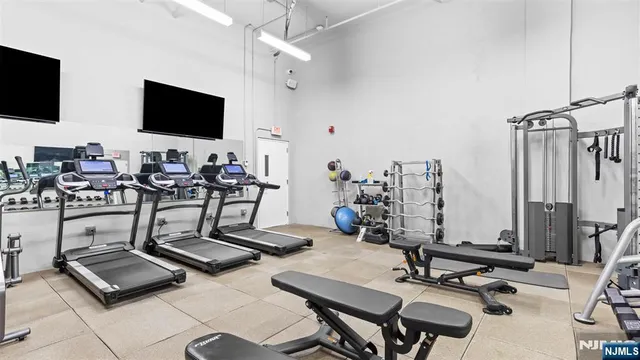 a room with gym equipment and a flat screen tv
