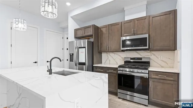 a kitchen with stainless steel appliances a stove a sink and cabinets