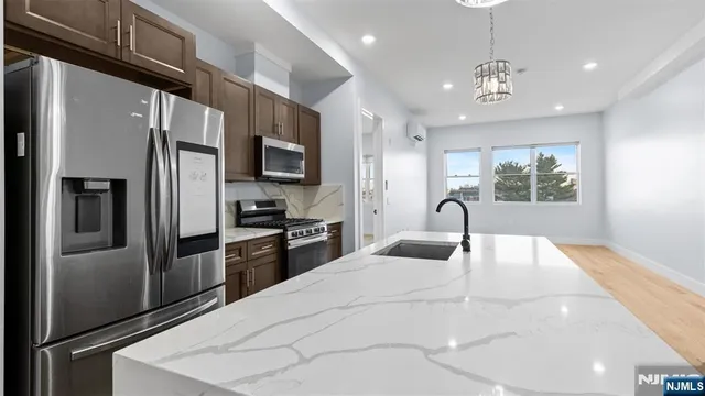 a large white kitchen with stainless steel appliances