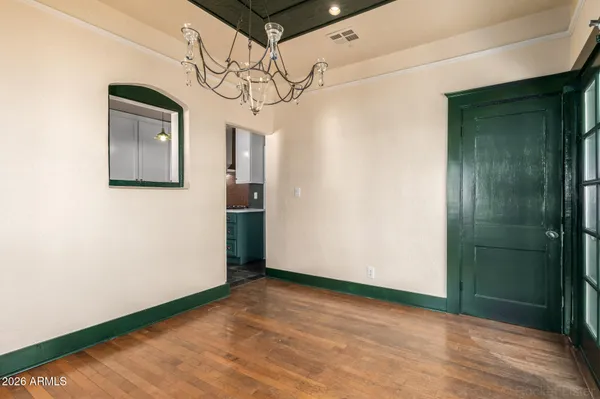 a view of a hallway with wooden floor and chandelier