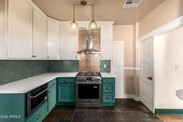 a kitchen with a stove and a chandelier