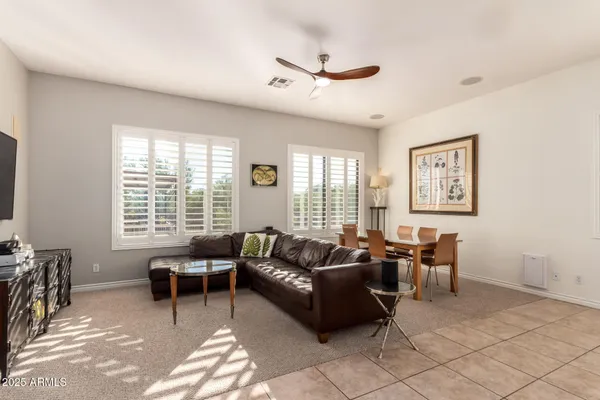 a living room with furniture a dining table and a large window