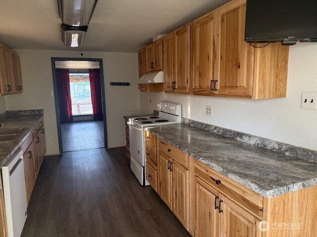 1206 Sunset Street Southeast Ephrata, WA 98823 - Photo 9 of 11 a kitchen with stainless steel appliances granite countertop a stove a sink dishwasher and a microwave oven with wooden floor