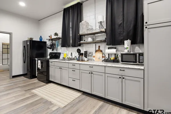 a kitchen with stainless steel appliances a refrigerator sink and microwave