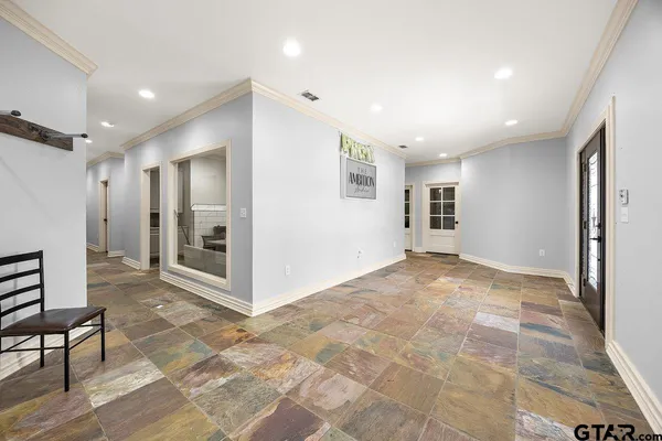 a view of a hallway with wooden floor and a living room
