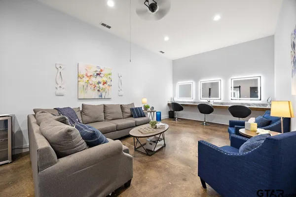 a living room with furniture kitchen view and a window