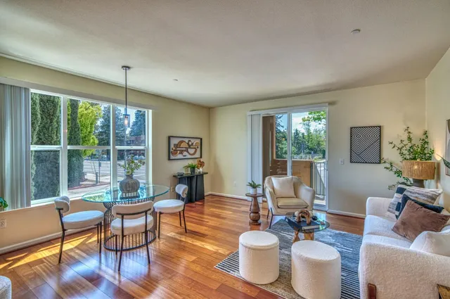 a living room with furniture a flat screen tv and a large window
