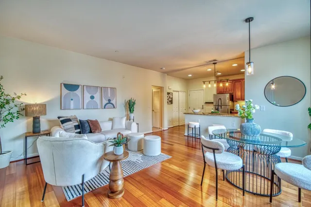 a living room with furniture a mirror and a chandelier