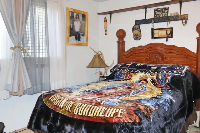 a bedroom with a bed and painting on the wall