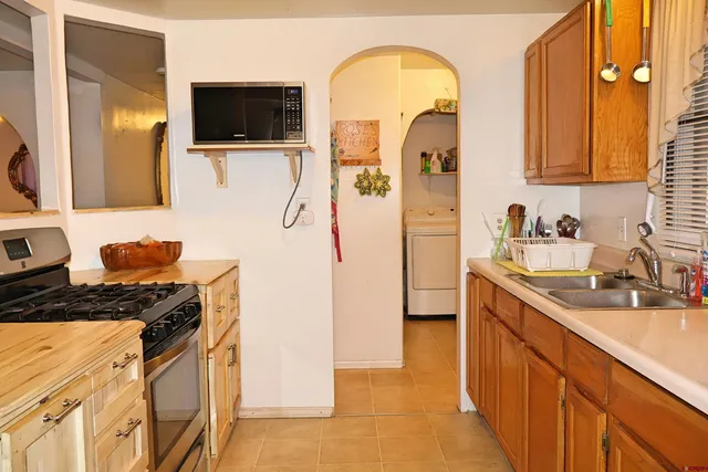 a kitchen with stainless steel appliances granite countertop a sink a stove and a refrigerator