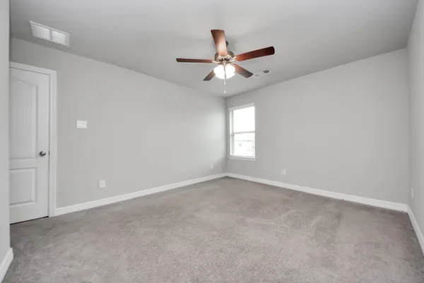 an empty room with windows and fan