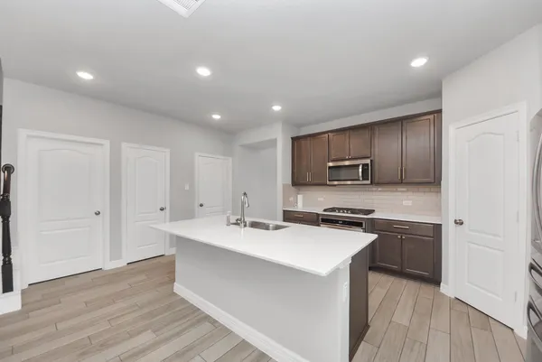 a kitchen with a sink a stove a refrigerator and cabinets