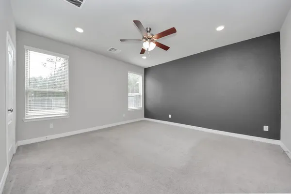 an empty room with window and ceiling fan