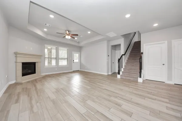 an empty room with wooden floor and fireplace