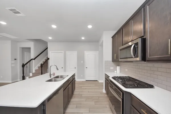 a kitchen with granite countertop a sink and stove top oven