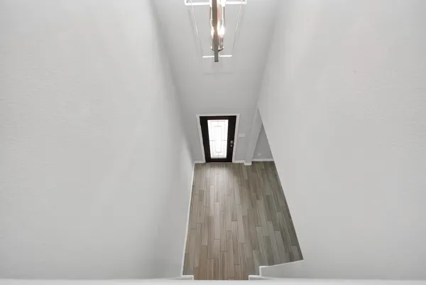 a view of a hallway with wooden floor and a window
