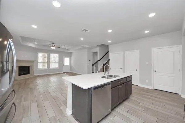 a large kitchen with stainless steel appliances granite countertop a lot of counter space and a wooden floor