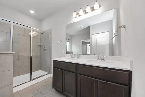 a bathroom with a double vanity sink mirror and shower