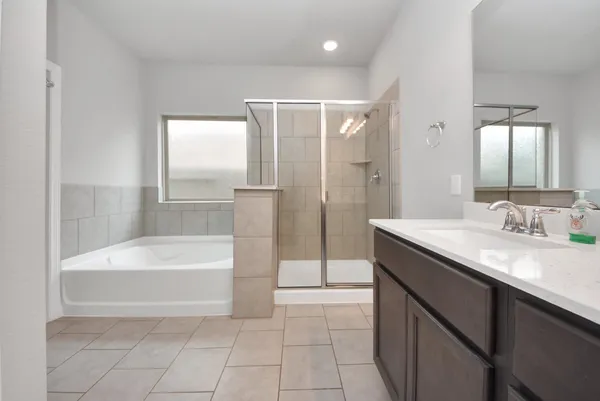 a spacious bathroom with a bathtub sink and mirror