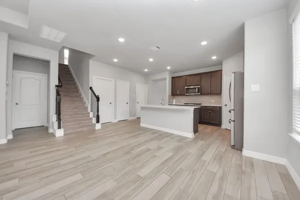 a view of a kitchen with wooden floor and electronic appliances