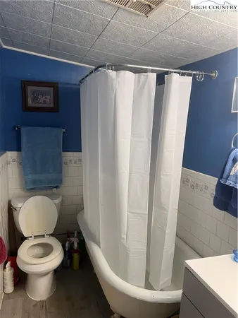 a white toilet sitting next to a shower