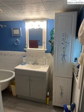 a bathroom with a sink and mirror with bathtub