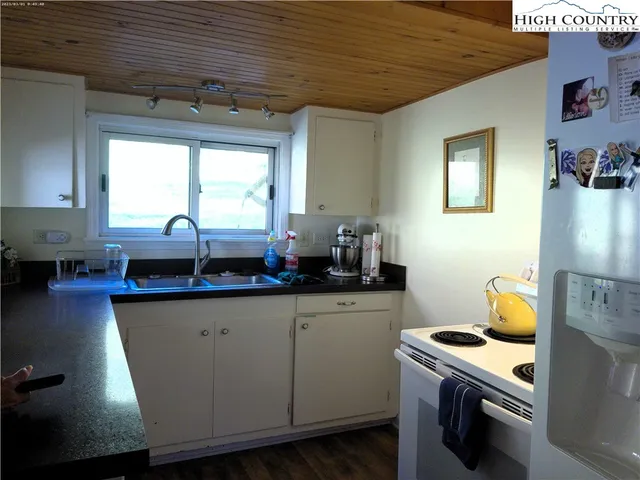 a kitchen with granite countertop a sink a stove and cabinets