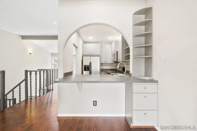 a kitchen with granite countertop a sink stainless steel appliances and cabinets
