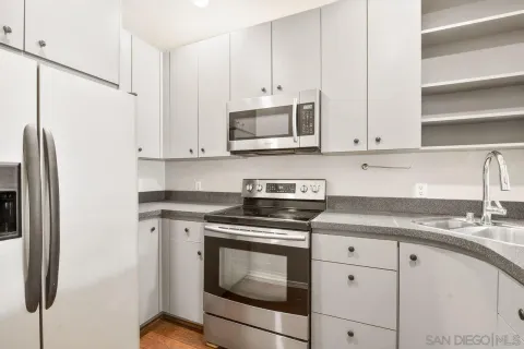 a kitchen with granite countertop a sink stainless steel appliances and cabinets