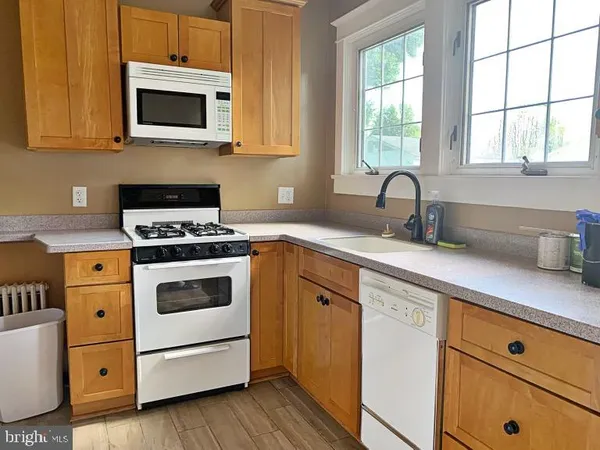a kitchen with cabinets appliances a sink and a window