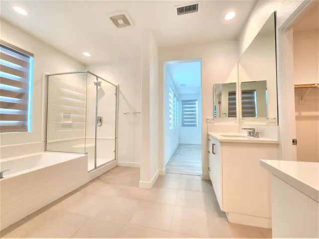 a bathroom with a tub sink shower and mirror