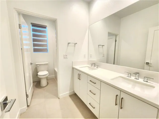 a spacious bathroom with a granite countertop sink toilet and shower