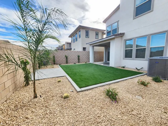 a view of a white house with a yard and potted plants