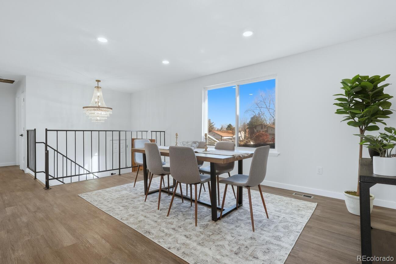 3173 South Nucla Street Aurora, CO 80013 - Photo 3 of 34 a dining room with furniture potted plants and wooden floor