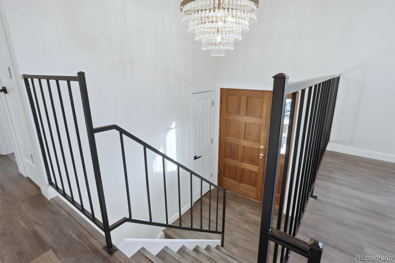 3173 South Nucla Street Aurora, CO 80013 - Photo 6 of 34 a view of a hallway with wooden floor and staircase