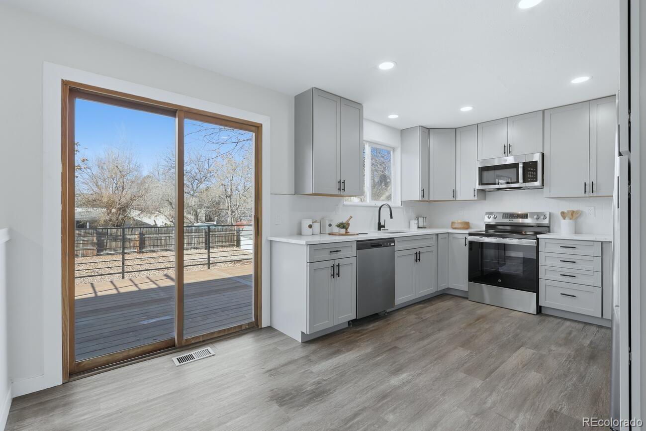 3173 South Nucla Street Aurora, CO 80013 - Photo 7 of 34 a kitchen with a stove a sink and a microwave