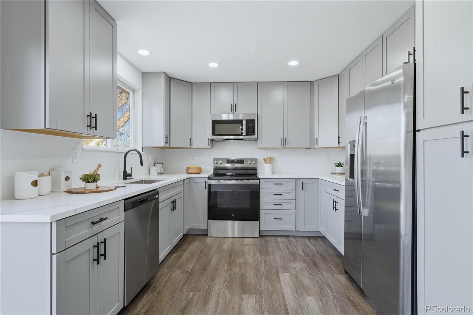 3173 South Nucla Street Aurora, CO 80013 - Photo 8 of 34 a kitchen with a refrigerator a stove top oven a sink and cabinets