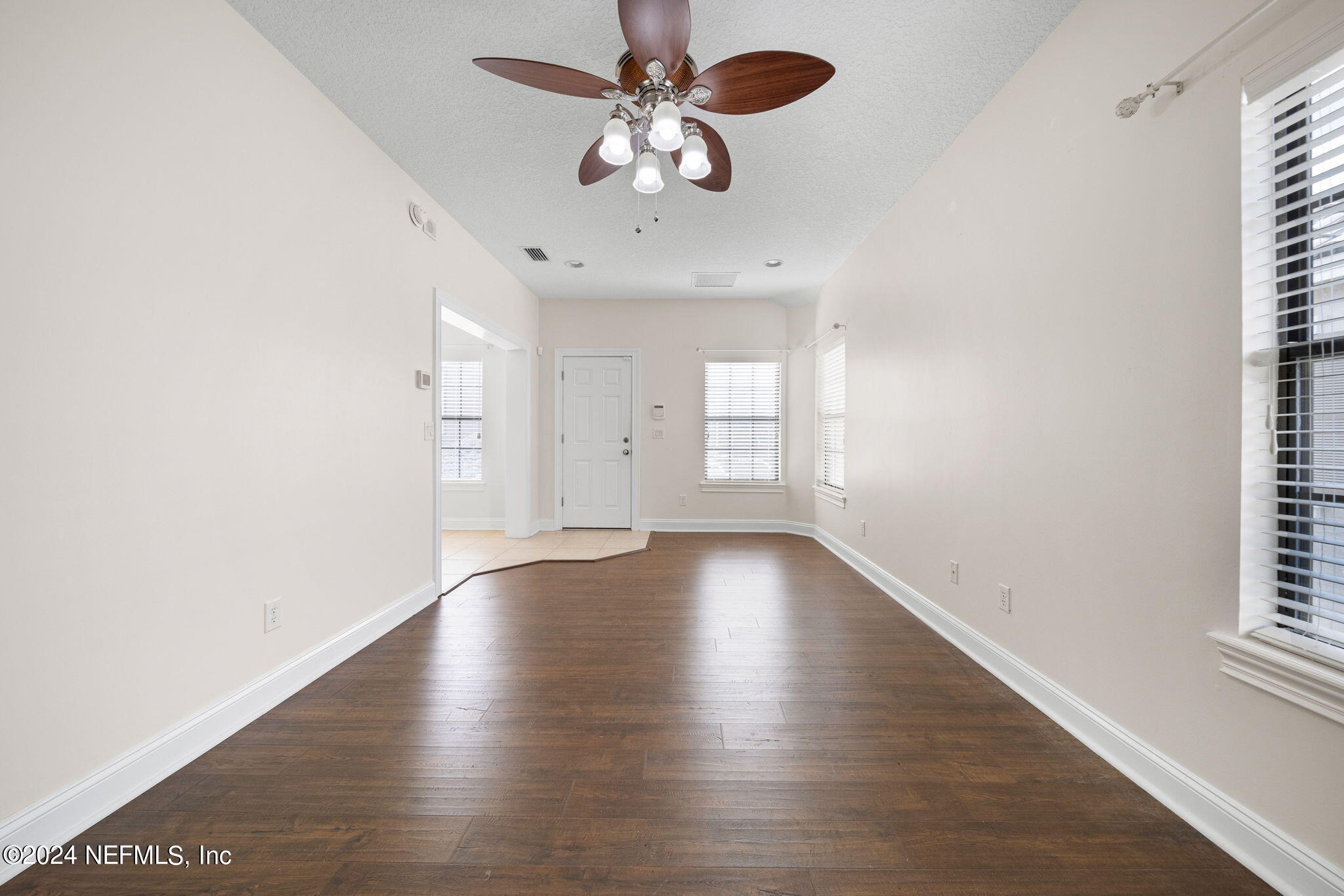 650 South Loop Parkway St. Augustine, FL 32095 - Photo 25 of 42 an empty room with wooden floor chandelier fan and windows
