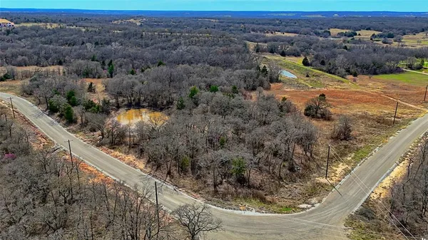 a view of a dry yard with mountains in the background