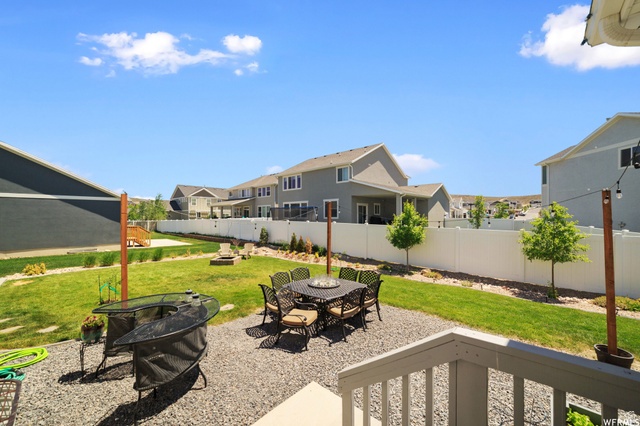 1836 Red Oak Road Eagle Mountain, UT 84005 - Photo 13 of 15 Fenced backyard with a patio area, an outdoor fire pit, a residential view, and outdoor dining space