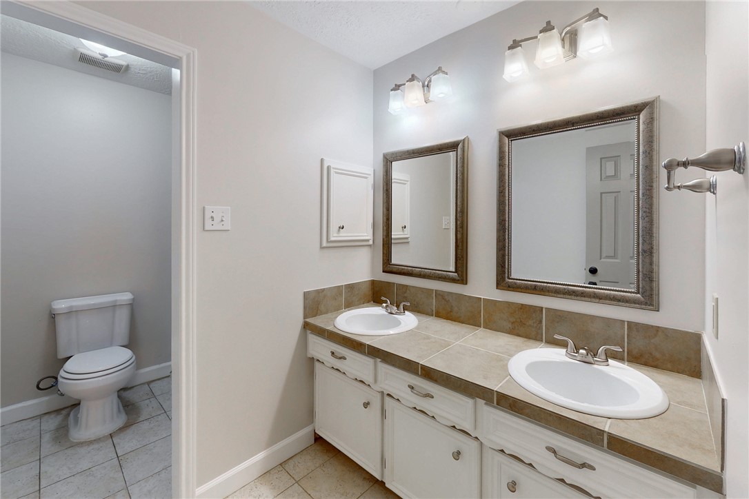 1308 Hawk Tree Drive College Station, TX 77845 - Photo 16 of 34 a bathroom with a granite countertop sink and a mirror