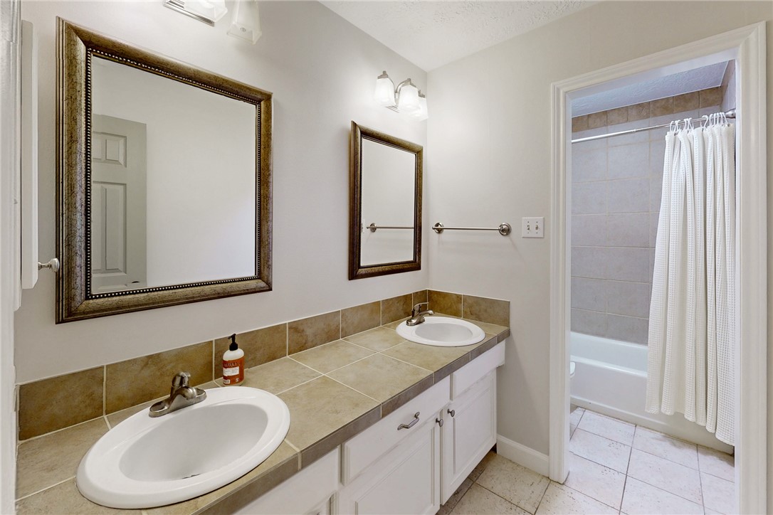 1308 Hawk Tree Drive College Station, TX 77845 - Photo 21 of 34 a bathroom with a granite countertop sink and a mirror